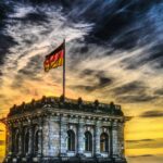 Vibrant sunset over a historic Berlin monument with the German flag waving.